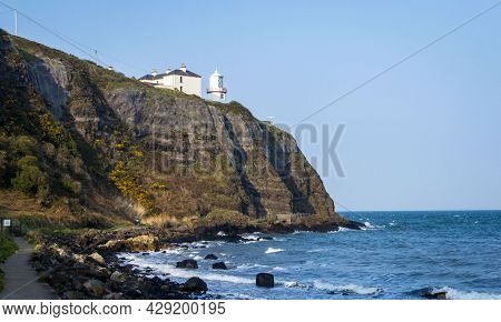 Whitehead, Carrickfergus, Uk, April, 2019. The Blackhead Lighthouse At Whitehead In A Sunny Day.