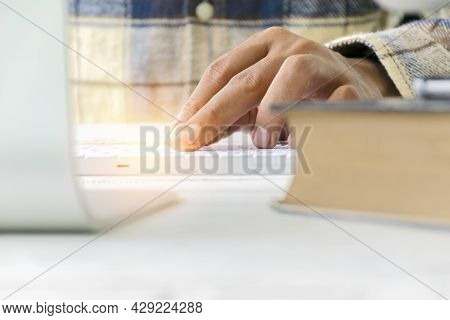 Work Hard To Get The Best Job. Young Man Using A Computer, Hand Held Mouse And Keyboard, On A Clean 
