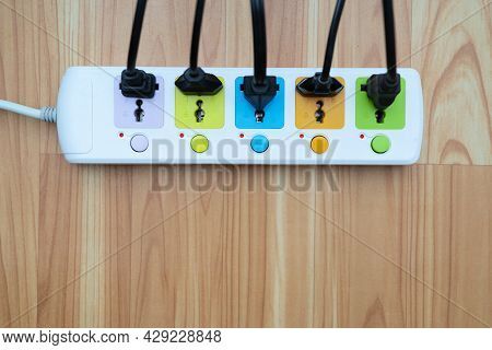 Plug Strip With A Red On Off Switch On The Floor, White Power Extension Cord Plugs Connected To It, 