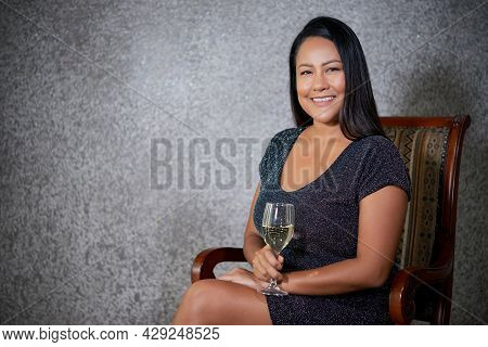 Attractive Cheerful Woman With Long Black Hair Enjoying Glass Of Sparkling Wine