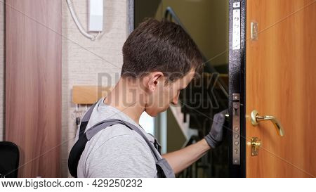Professional Craftsman In Jumpsuit Checks Modern Entrance Door Outer Lock Twisting Lever And Pressin
