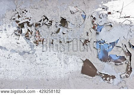 Detail Of Peeling, Cracked And Flakey Paint On A Metal Surface. Light Coloured Paint Peels And Crack