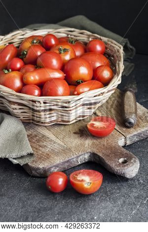 Fresh Red Tomatoes In Whicker Basket On Black Background