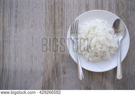 Thai Fragrant Jasmine Rice Scooped Into Served In A White Plate On A Brown Wooden Table. Rice That O