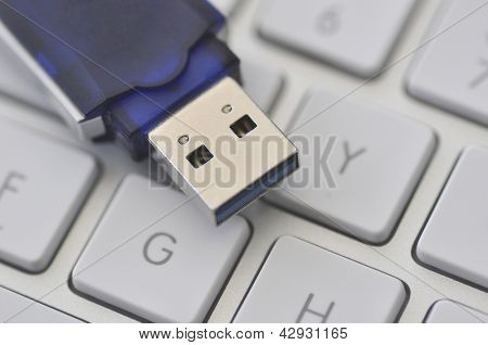 Nærbillede af USB memory stick hvilende på computerens tastatur