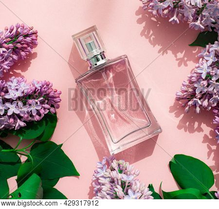 A Bottle Of Perfume And Lilac On A Pink Background . Womens Perfume. Spring Fragrance. Aromatherapy.