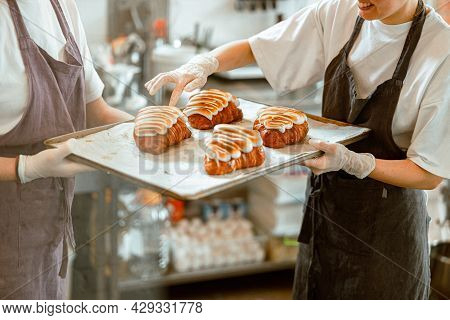 Inspertor Checks Croissants Decorated With Burnt Cream With Colleague In Craft Bakery