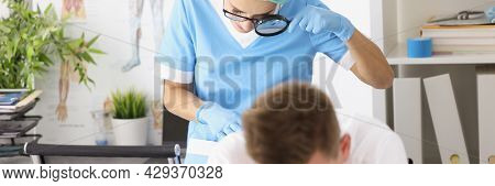 Dermatovenerologist Doctor Examining Skin On Buttocks Of Male Patient Using Magnifying Glass