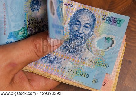 Male Hand Holds A Fan Of  Vietnames Dong Banknote, The Currency Of Vietnam.  Close Up Polymer Money 