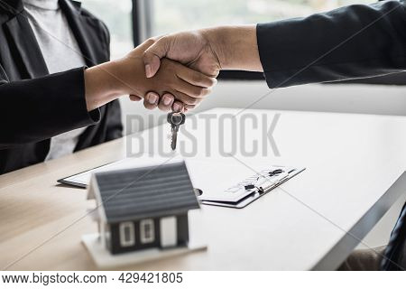 Salesperson And Customer Shake Hands After Signing The Contract, The Salesperson Explains The Detail