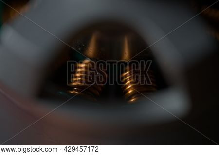 Dark Close Up Of Shiny Copper Coils Within A Brushless Drone Motor. Copy Space And Selective Focus W