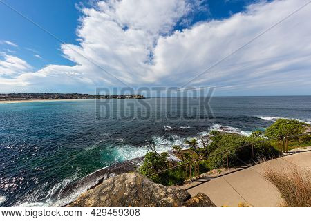 The Rocky Shoreline Around Bondi Beach, Sydney, Australia. Waves Splashing At The Rocks In The Water