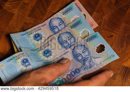 Male Hand Holds A Fan Of  Vietnames Dong Banknote, The Currency Of Vietnam.  Close Up Polymer Money 