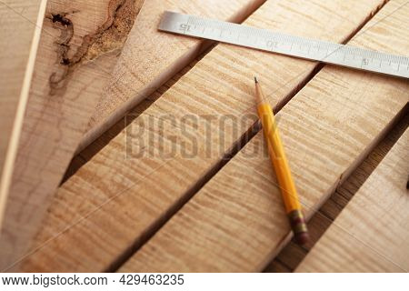Woodworking with curly maple (or tiger maple) a sought after and prized wood for its beautiful figured grain. Wood working lumber on work bench.Shallow depth of field.