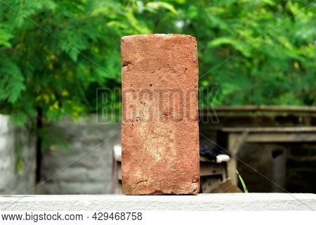 A Single Old Red Brick With Nice Blurry Green Background Countryside Of India