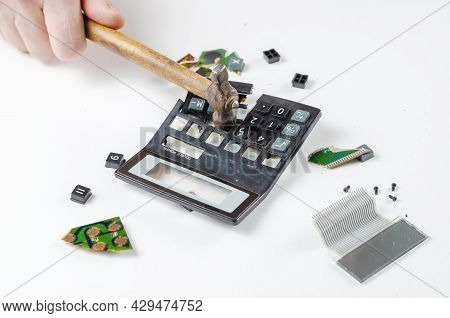 Nervous, Irritated Man Smashes Calculator With Hammer. His Hand Hits The Plastic Casing Of The Elect