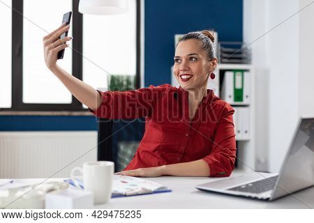 Successful Businesswoman Having Fun At Work Taking Selfies, Sitting At Desk Office Workplace Using S