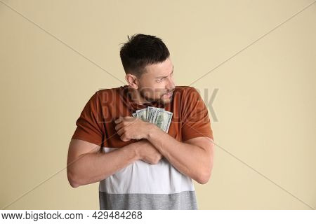 Greedy Man Hiding Money On Beige Background