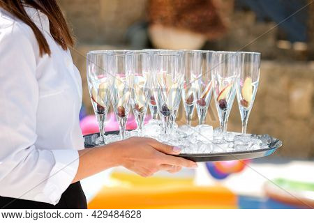 Midsection Of Waiter Offering Champagne At Poolside.serving With Ice On A Tray. Swimming Pool Party 