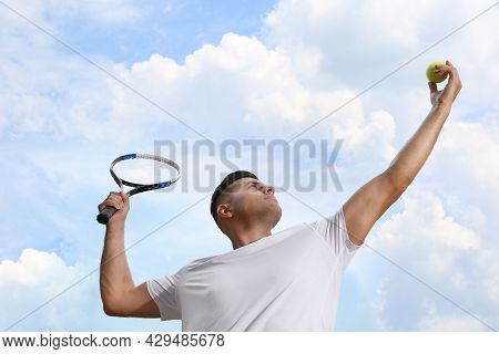 Man Serving Ball While Playing Tennis Outdoors, Low Angle View