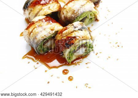 Close Up Of 6 Piece Sushi Set With Eel, Shrimp In Tempura, Cucumber, Topped With Dressing, On White 
