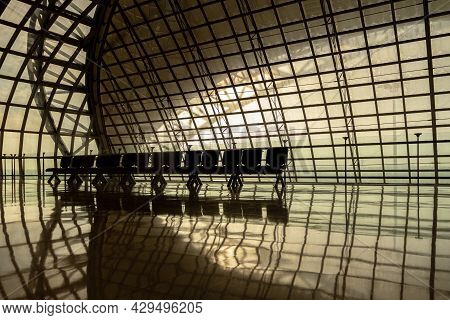 Silhouette Metal Structure Of Modern Building Architecture And Empty Waiting Chairs With Warm Sunlig