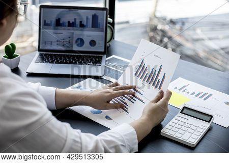 A Woman Holding A Sales Summary, The Sales Manager Is Looking At The Monthly Sales Summary Document