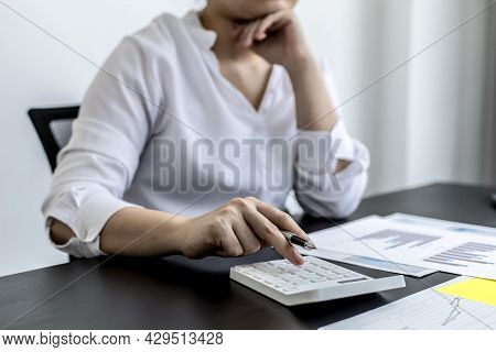 A Businesswoman Is Pressing A White Calculator, She Is Calculating The Numbers On The Company Financ
