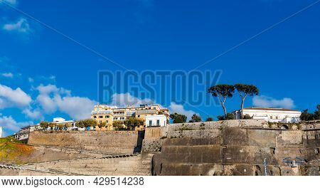 Sorrento, Italy - August 24 2020: Upward View To Buildings And Cliffs Next To Edge Of High Cliff
