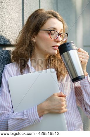 Female Portrait Of Young Woman With Silver Laptop And Cup Of Coffee Waiting For A Meeting Near Dark 