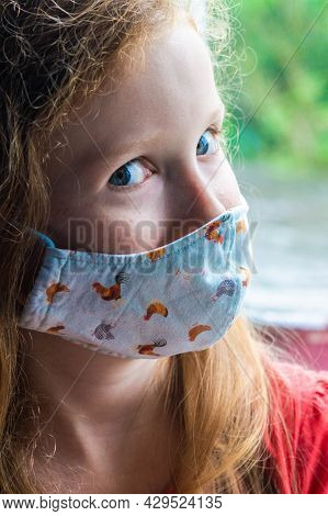 Young Girl Looking Cheaky In Lockdown Wearing A Face Mask For Covid-19 Prevention