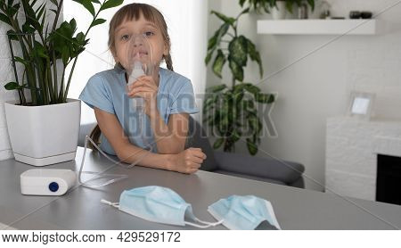 Little Girl Making Inhalation With Nebulizer At Home. Child Asthma Inhaler Inhalation Nebulizer Stea