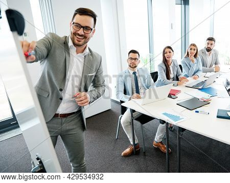Young Busnessman Having A Speech By A Whiteboard During A Conference Business Meeting In An Office. 