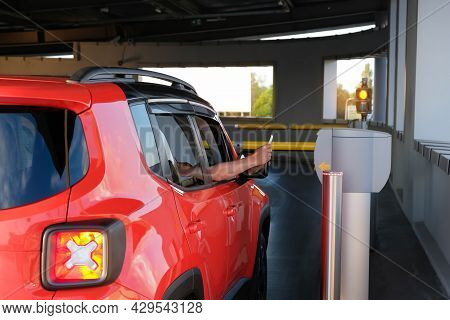A Man Takes A Parking Ticket At The Entrance To A Paid Underground Parking Lot For A Car. Parking Se