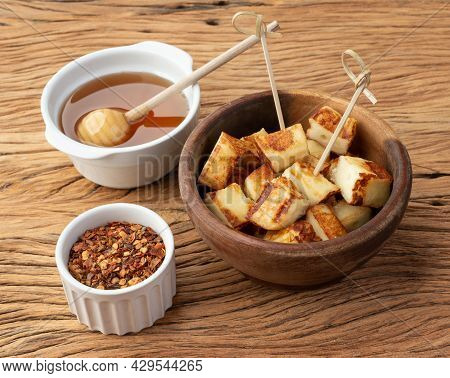 Grilled Rennet Or Coalho Cheese On A Wooden Bowl With Sugar Syrup And Pepper.