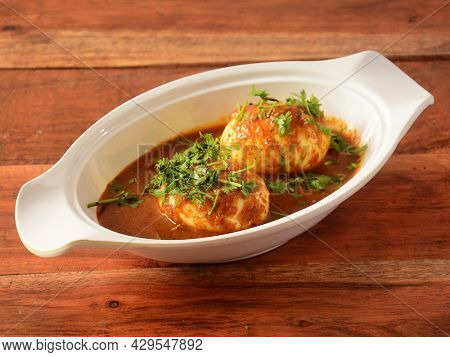 Anda Masala Or Egg Curry Is Popular Indian Spicy Food, Served In A Ceramic Bowl Over Rustic Wooden B