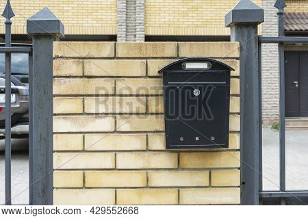 Mailbox Of A Private House, A Mailbox Made Of Black Metal Installed On A Brick Fence Of A Private Re