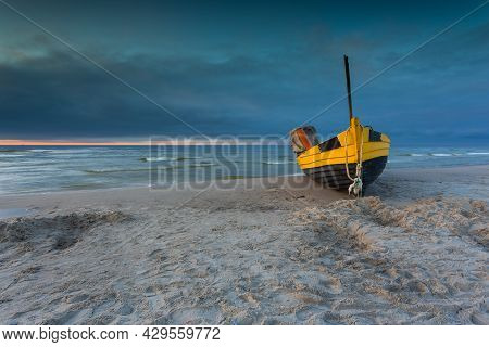 A Fishing Wooden Boat Moored By The Beach In Debki, Sunrise. Baltic Sea, Northern Poland.