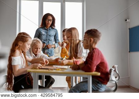 Happy Boys And Girls Using Wooden Math Tablet