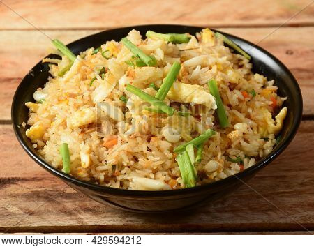 Indian Cuisine Healthy And Tasty Brunt Garlic Chicken Fried Rice Served In Black Bowl Over A Rustic 