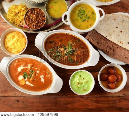 Assorted Indian Foods Paneer Butter Masala,channa Masala,roti And Veg Thali On Wooden Background. Di
