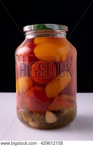 Canned Vegetables In A Jar On A White Table And Black Background.