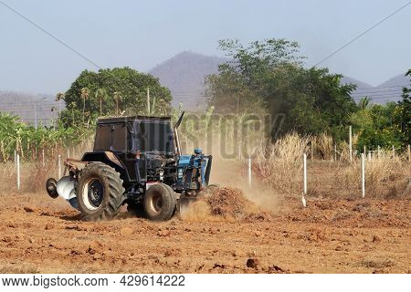 Tractor With Plougher And Grader Working In An Field