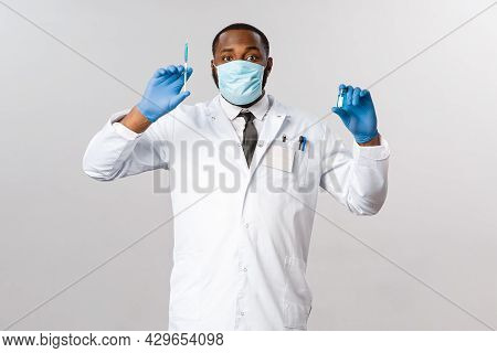 Covid19, Pandemic And Healthcare Concept. Cheerful Handsome African-american Doctor Showing Vaccine 