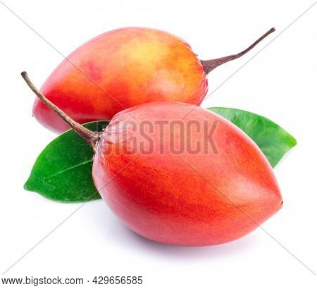 Two ripe tamarillo fruits with tamarillo leaves isolated on a white background.