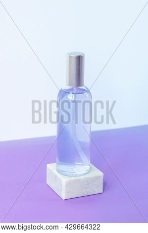 Lavender Water Or Hydrolat In Glass Bottle On Grey Podium On Purple Table. Aromatherapy Concept. Moc