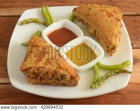 Bread Pakora Or Pakoda Served With Green Chilli And Sauces, A Famous Midday Snack In India, Served O