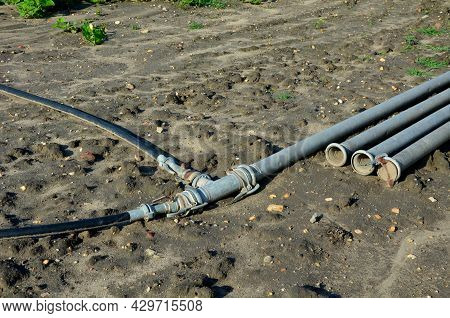Irrigation Pipes In The Field. Water Is Pumped From The River And Through Large Diameter Metal Pipes