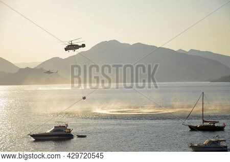 Russian KA-32 helicopter draws water from the sea to extinguish a forest fire. 30 July, 2021. Marmaris,Turkey