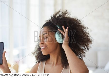 Young Trendy Woman In Big Headphones Listening Music And Dancing At Home.